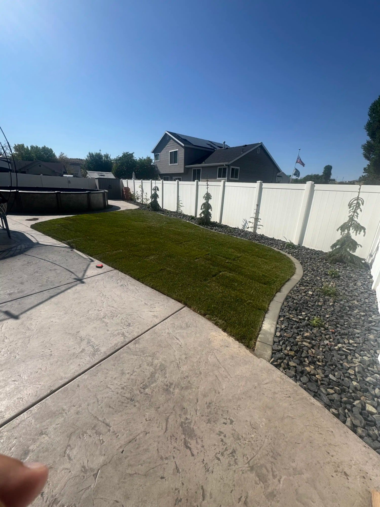 Backyard sod and rock border landscaping by EC Landscaping in North Salt Lake Utah