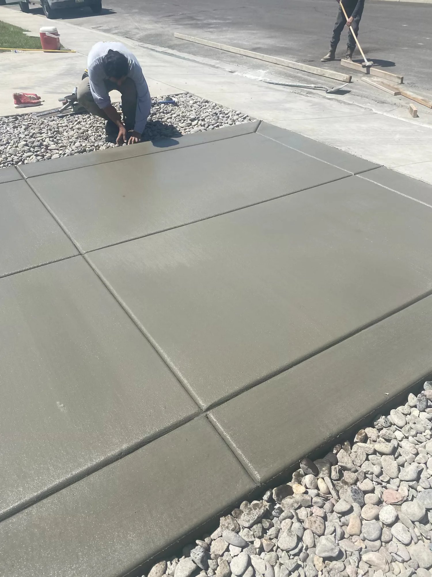Worker finishing concrete driveway edges Utah