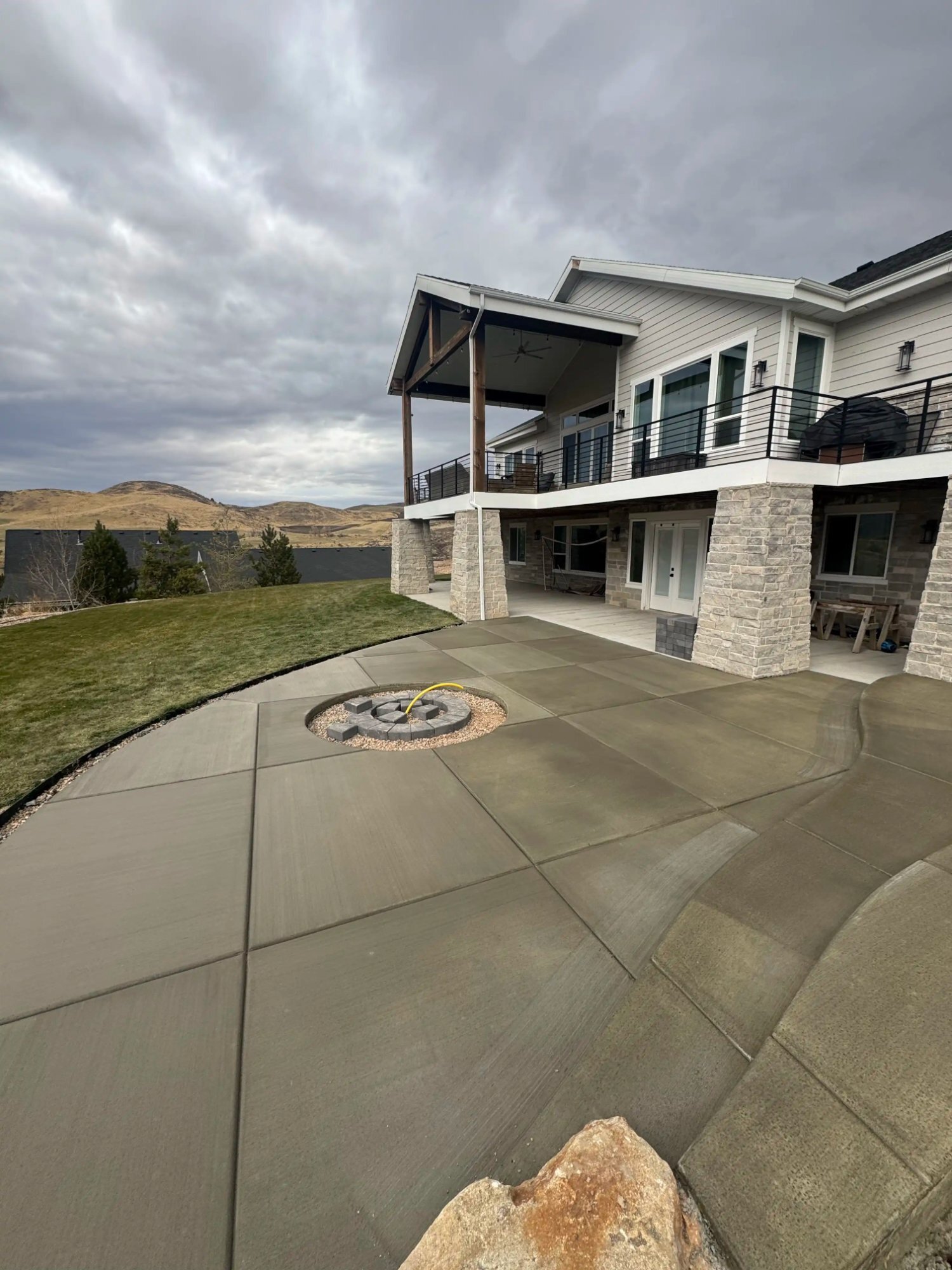Curved concrete patio with fire pit inset mountain view Utah