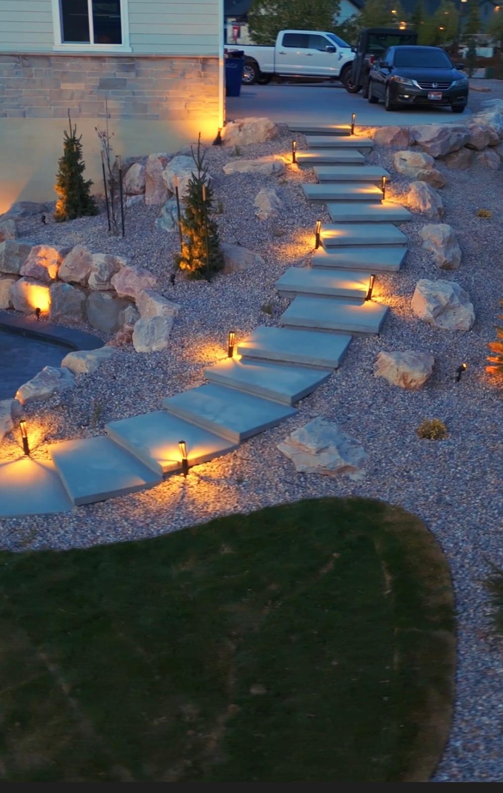 Flagstone garden pathway with professional low-voltage night lighting and natural boulders, Northern Utah