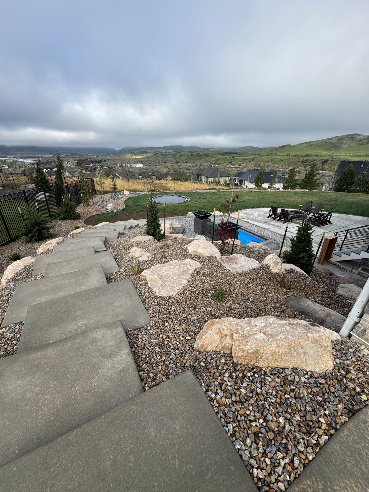 Top view of hillside stepping stone path with natural boulders and ornamental grasses, Northern Utah