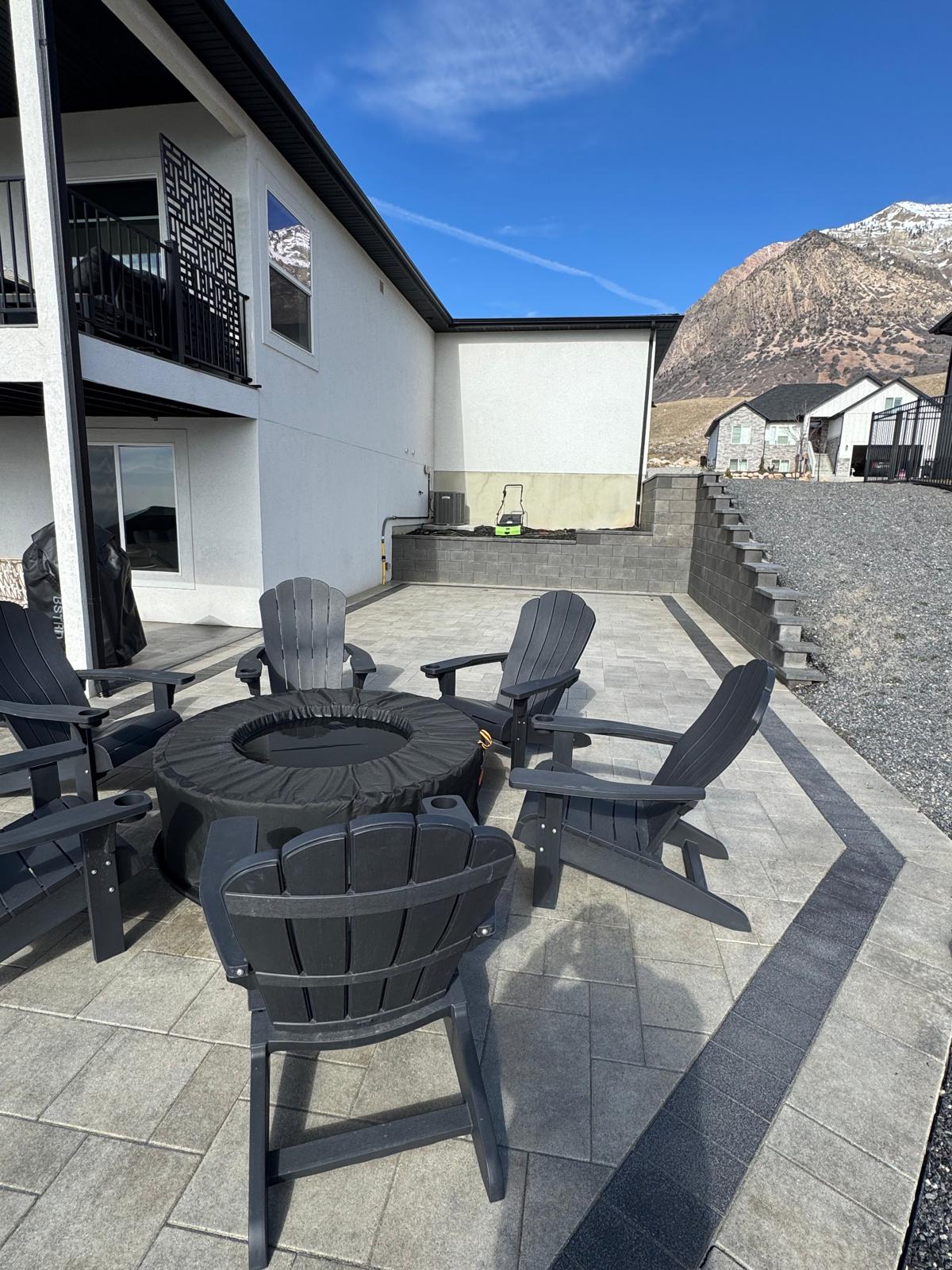 Custom built-in fire pit paver patio with Adirondack chairs overlooking the Wasatch Mountains, Northern Utah