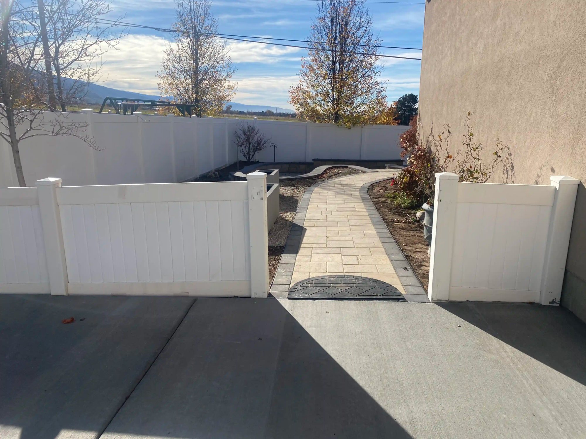 Curved paver walkway through a garden gate