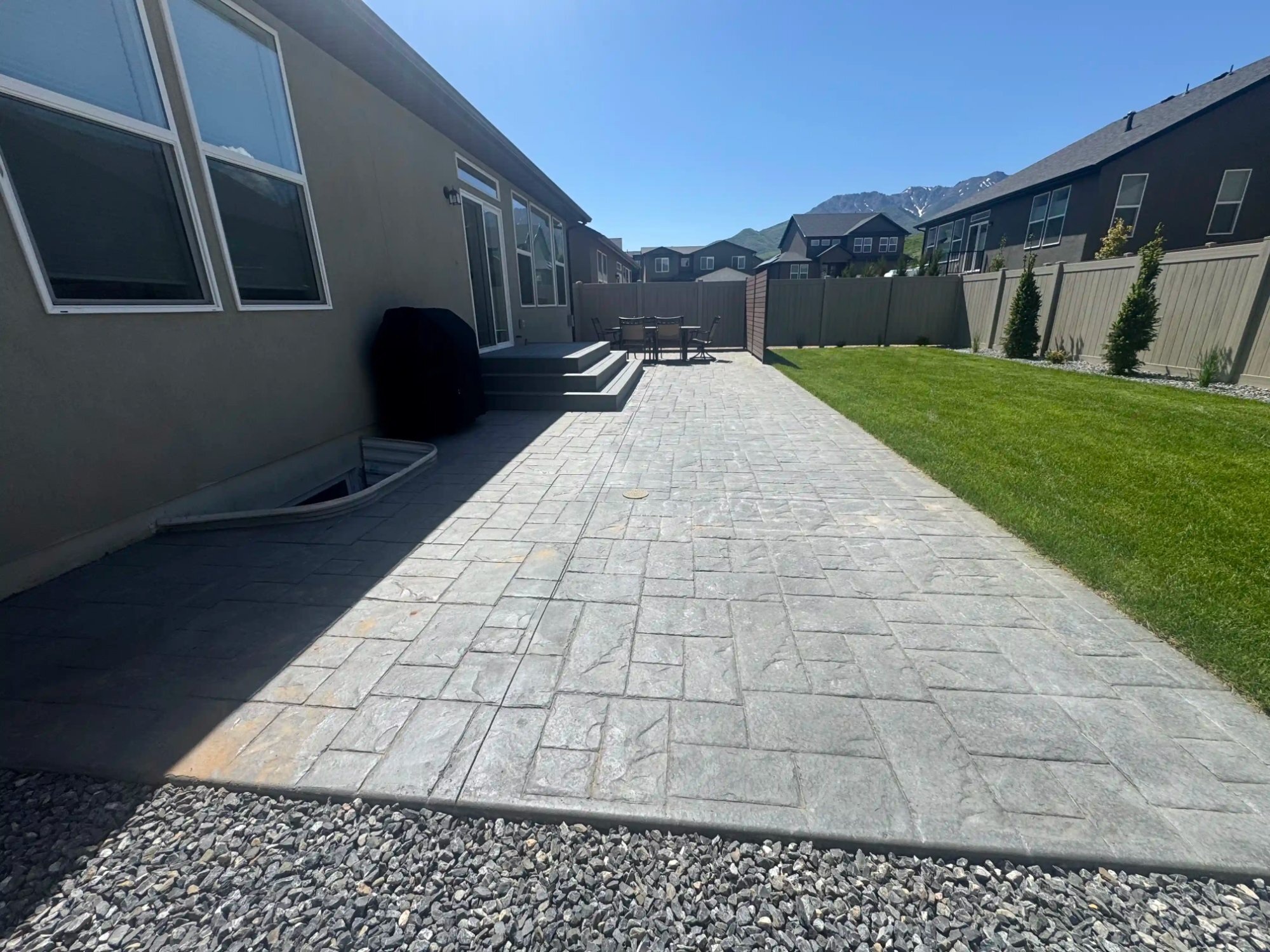 Large-stone-pattern paver patio and new lawn