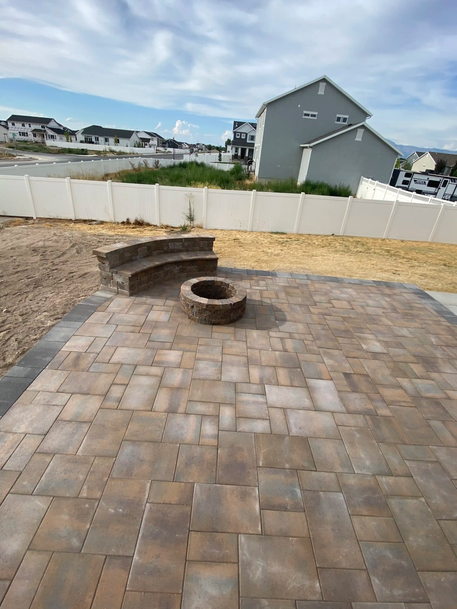 Curved paver patio with fire pit and seating wall, Northern Utah