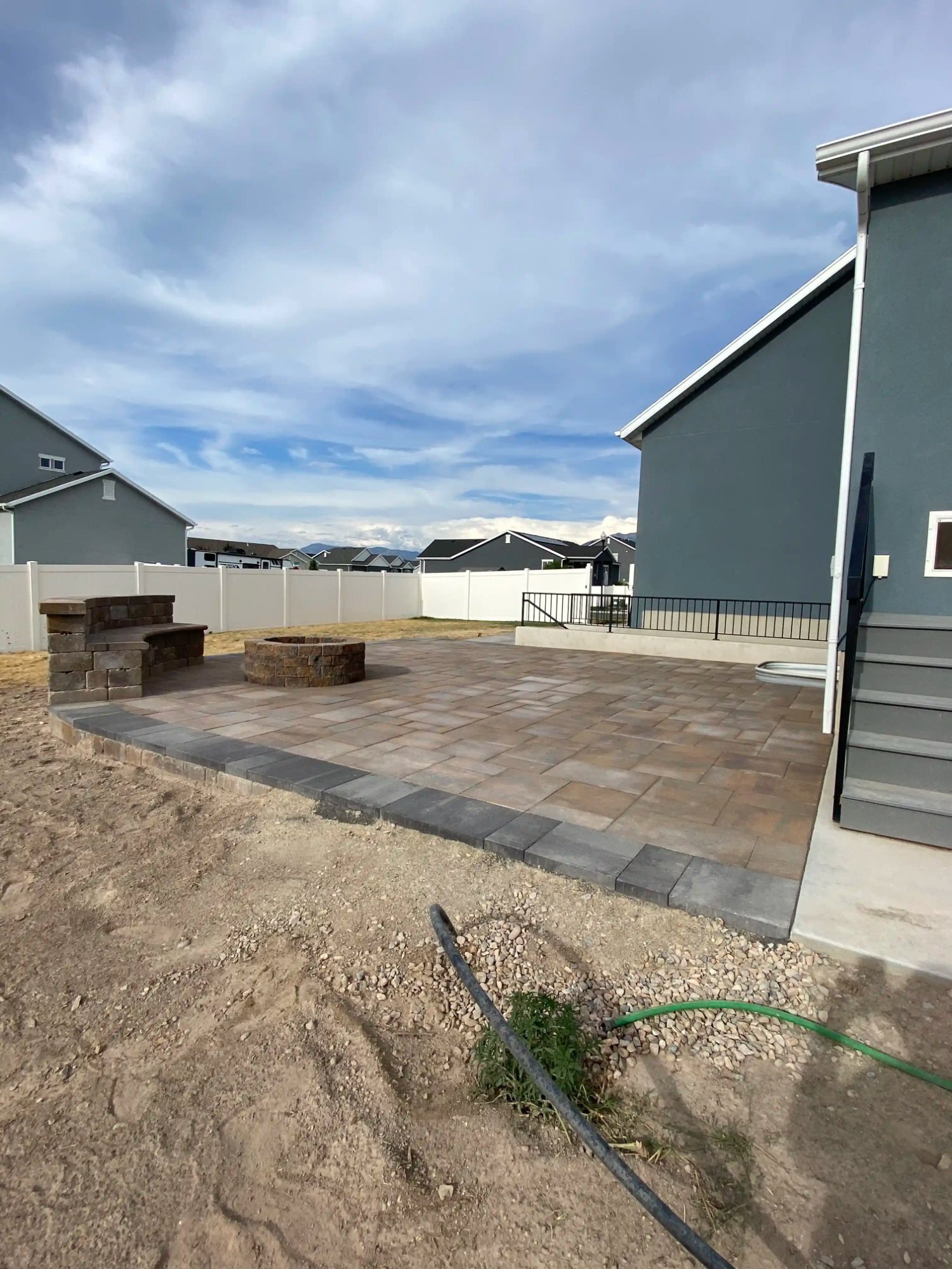 Backyard paver patio with fire pit and seating wall, Northern Utah